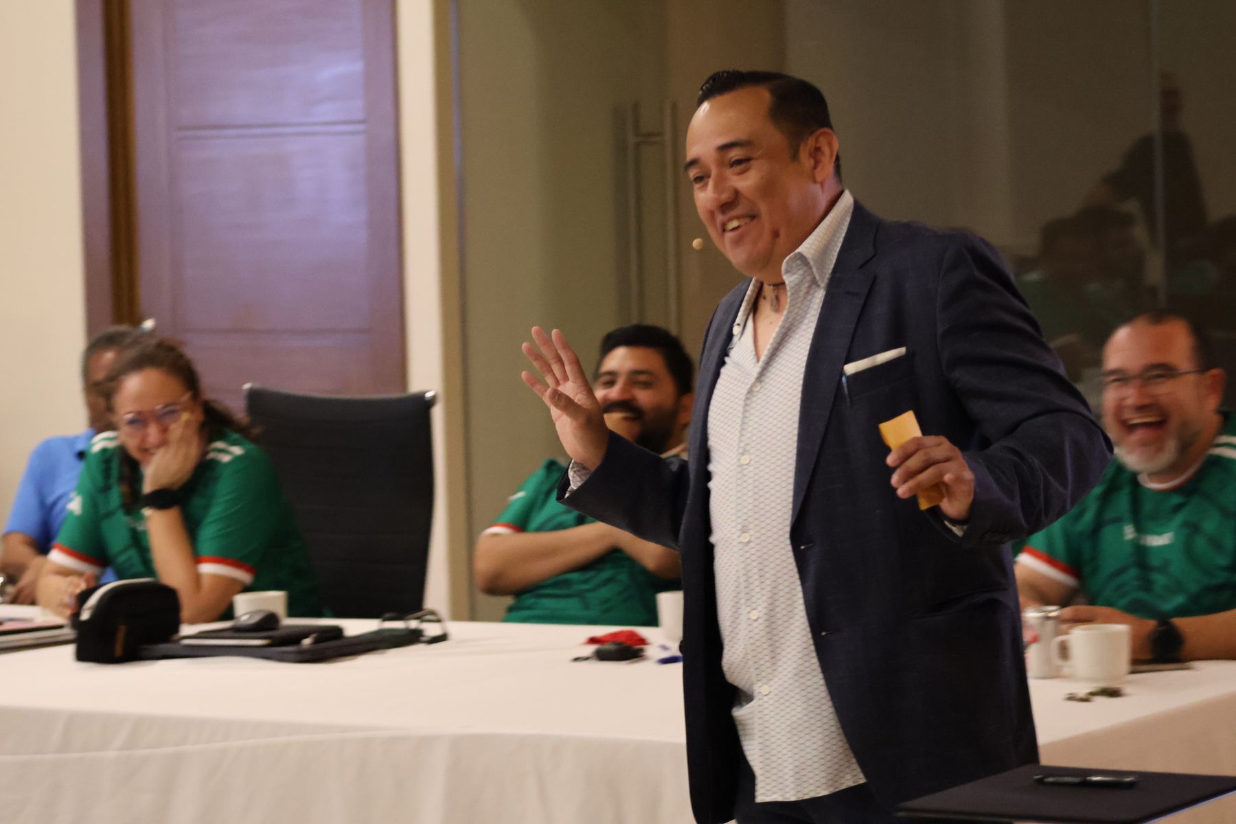 Ale Estrello presentando mientras el público sonríe