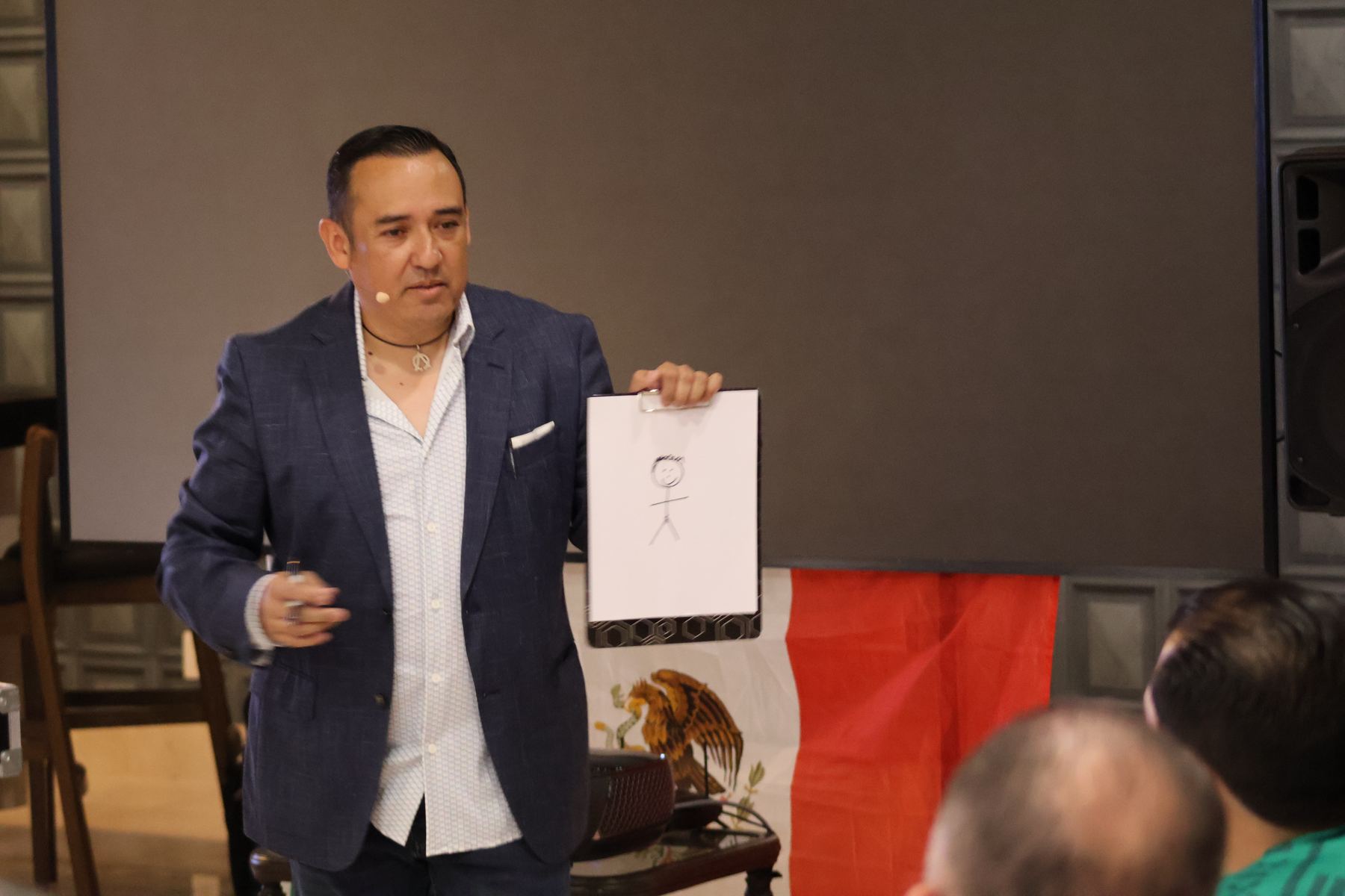 Ale Estrello en escena mostrando el dibujo de una predicción durante un evento corporativo
