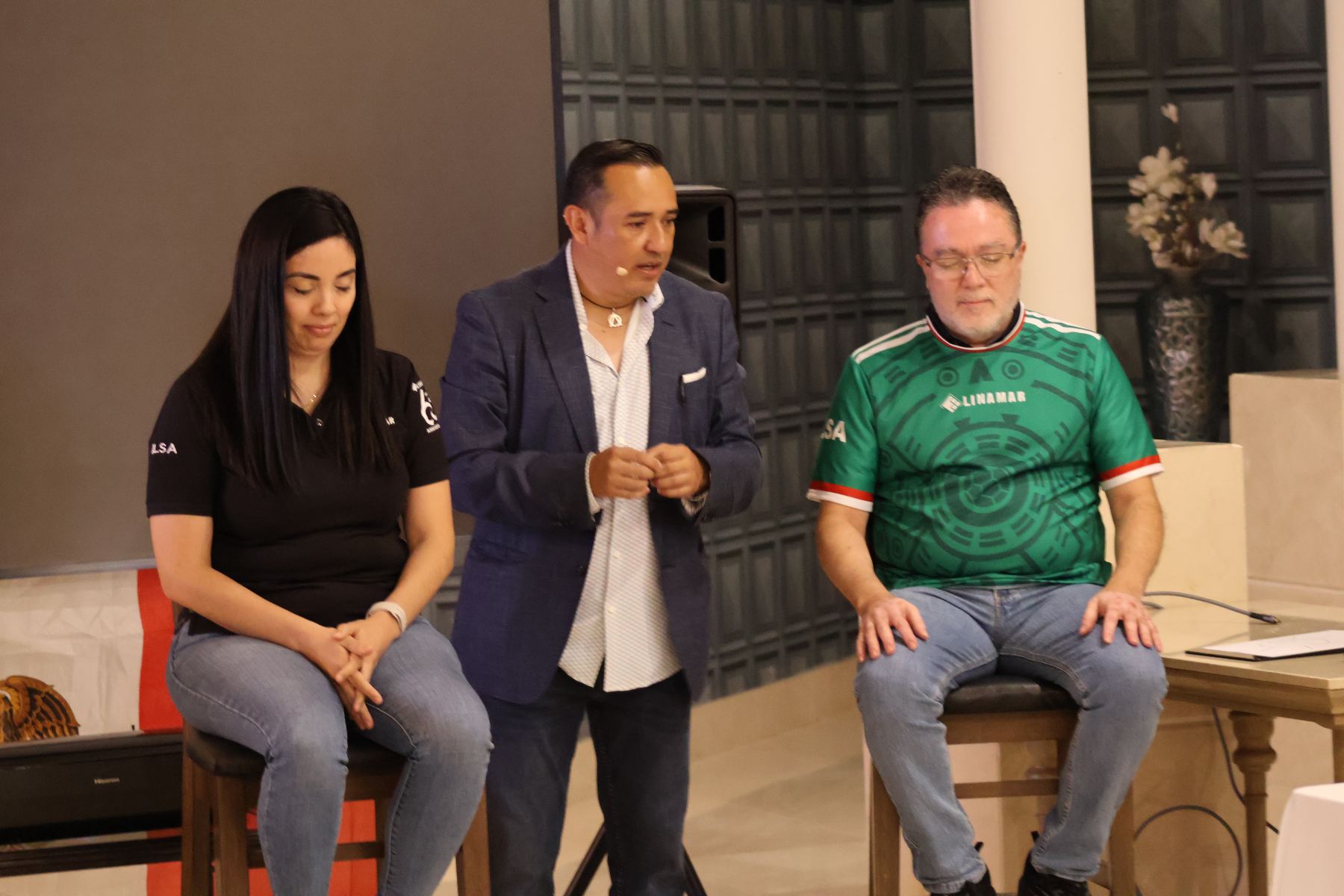 Ale Estrello en escena con dos participantes sentados