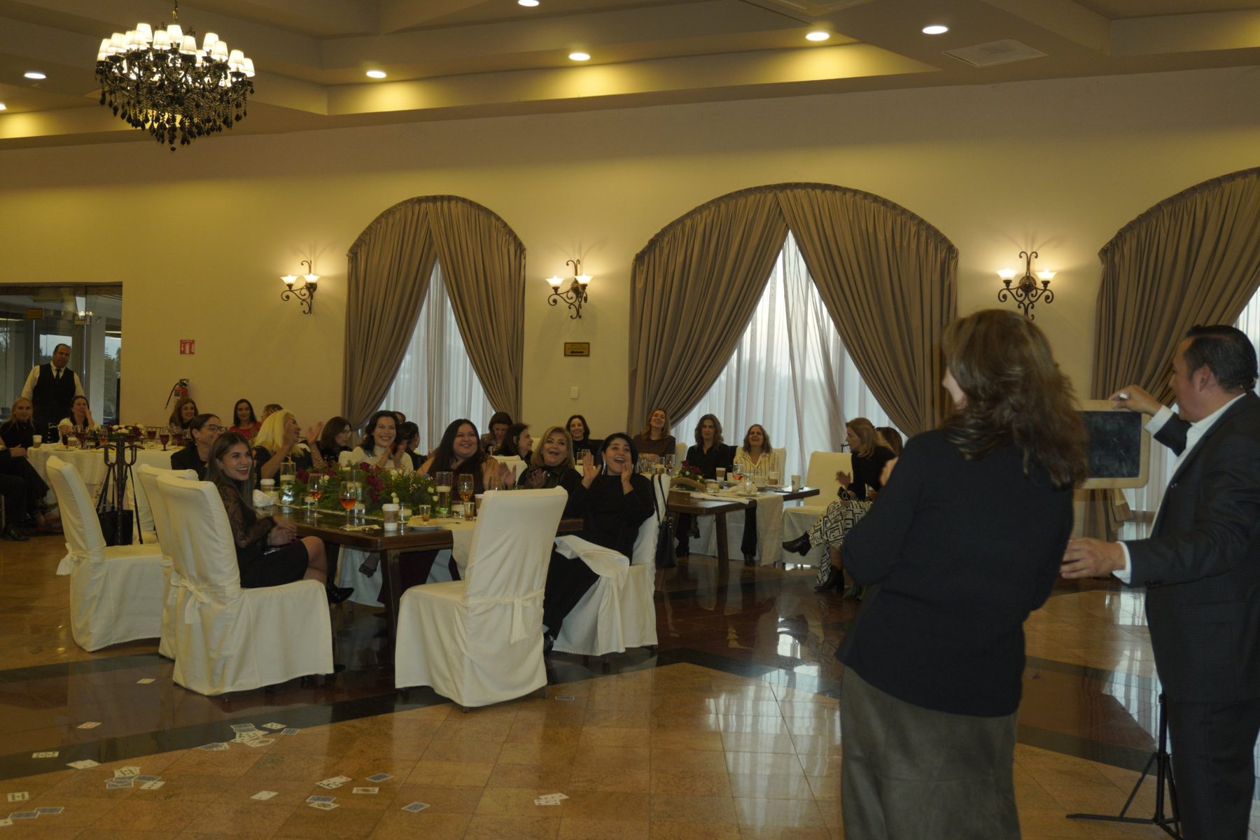 Las asistentes aplauden y ríen junto a una participante